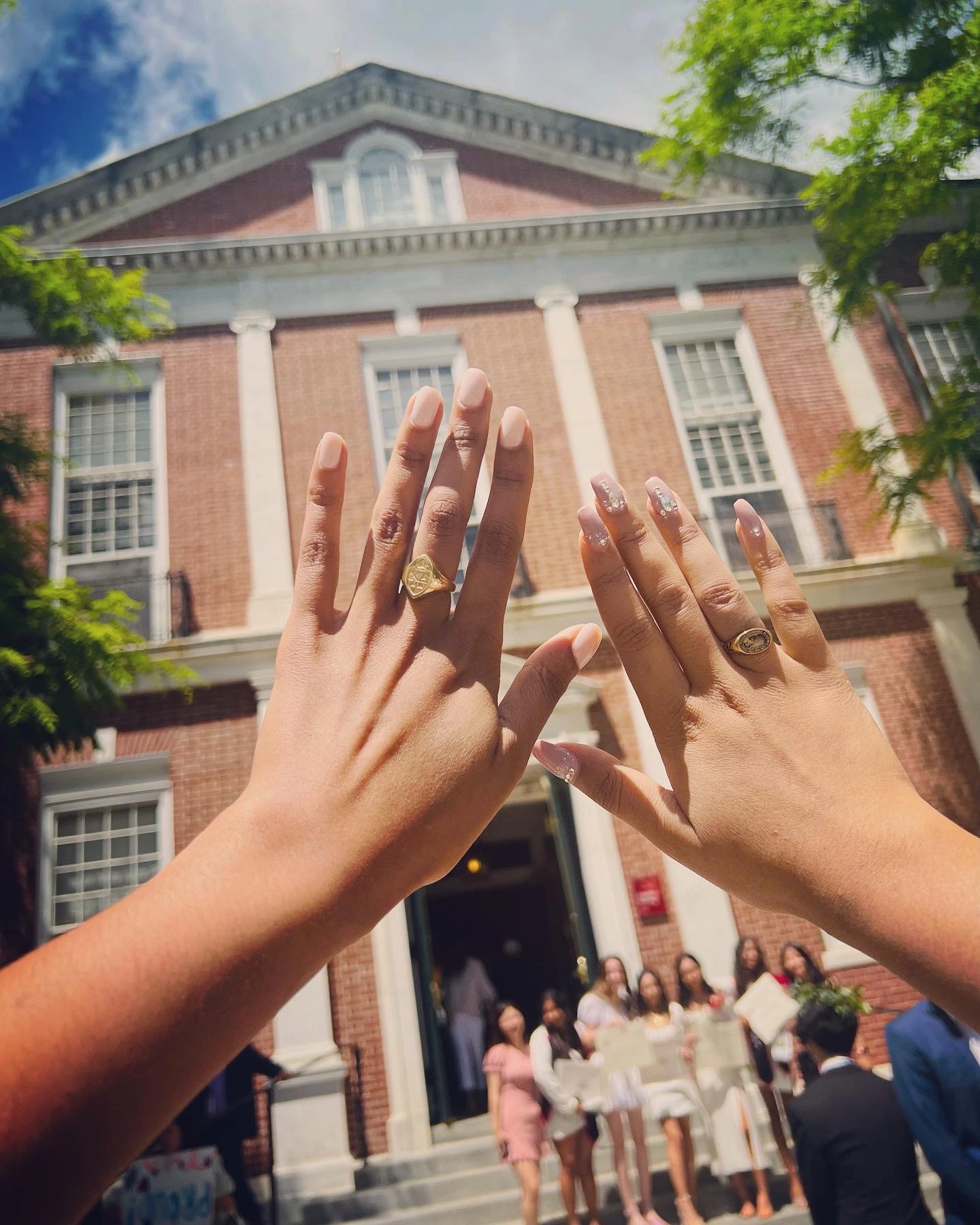 Graduation rings held up in front of Phillips Exeter Academy